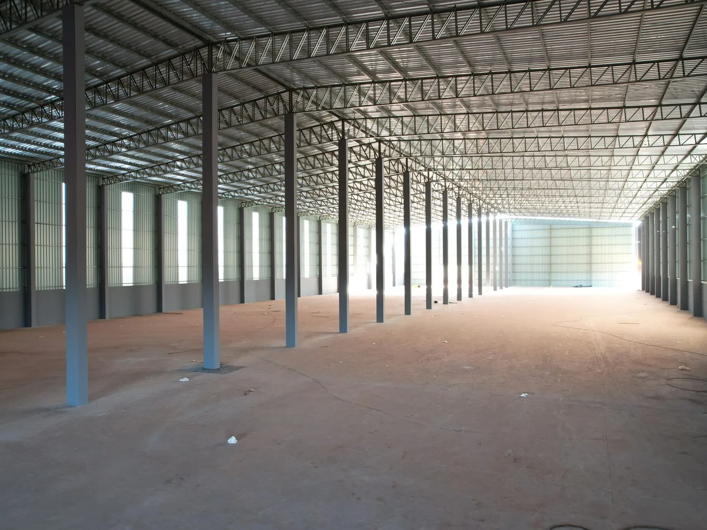 Interior de barracão com estrutura metálica de cobertura